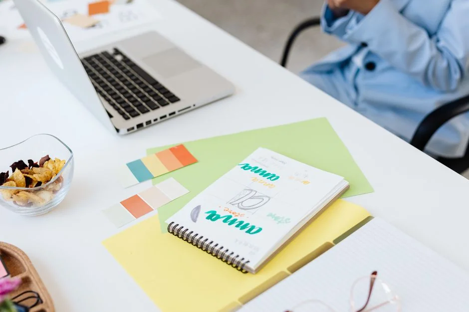 A designer sketches a mobile app prototype on paper at an office desk, focusing on creativity and design.